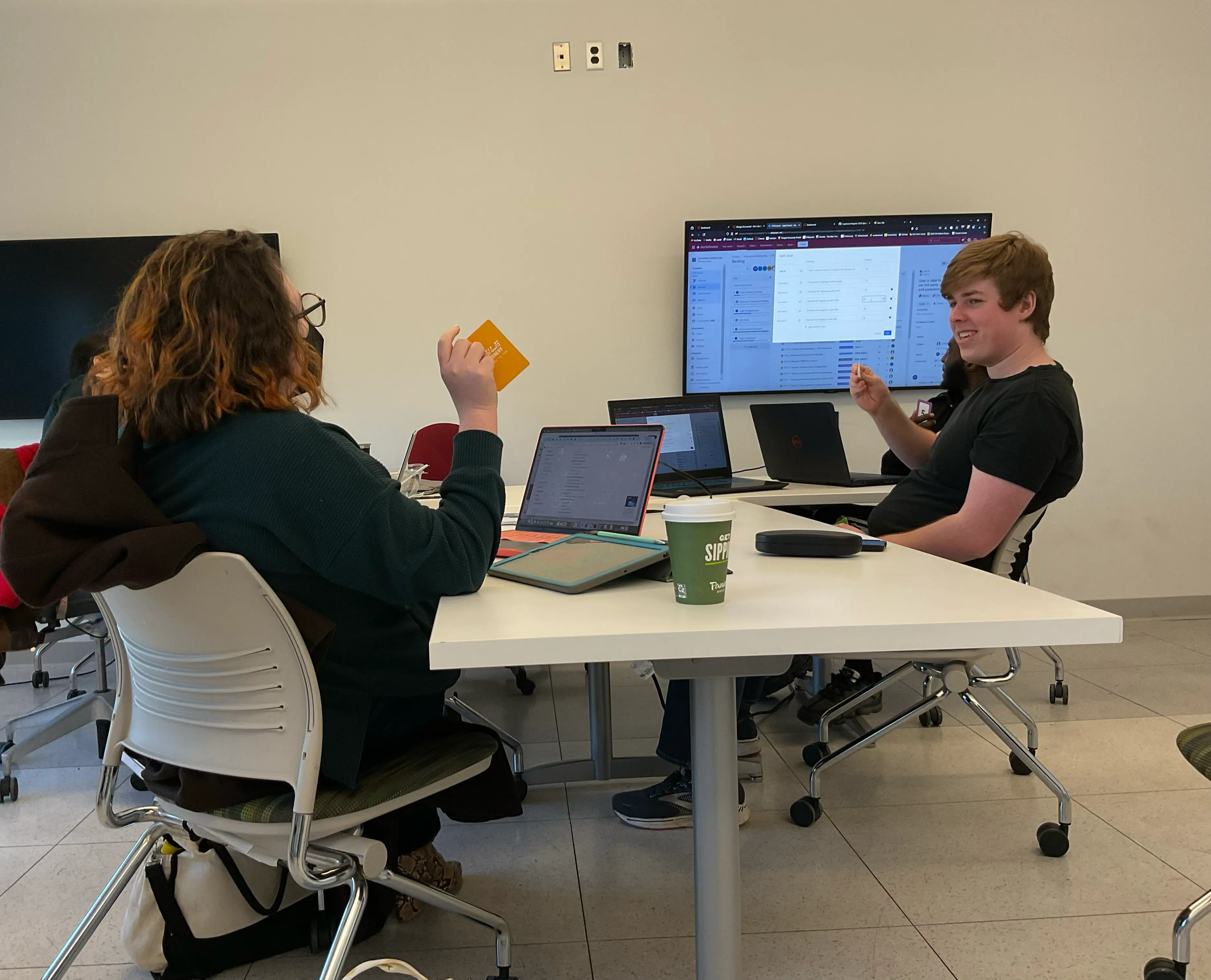 Students discussing project work in a classroom setting